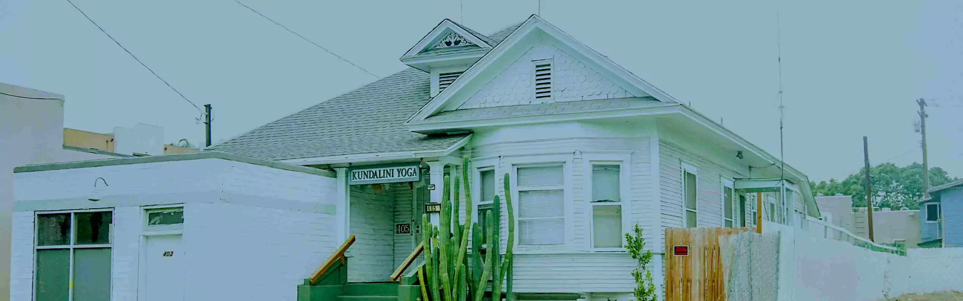 White house with Kundalini Yoga sign and cactus.