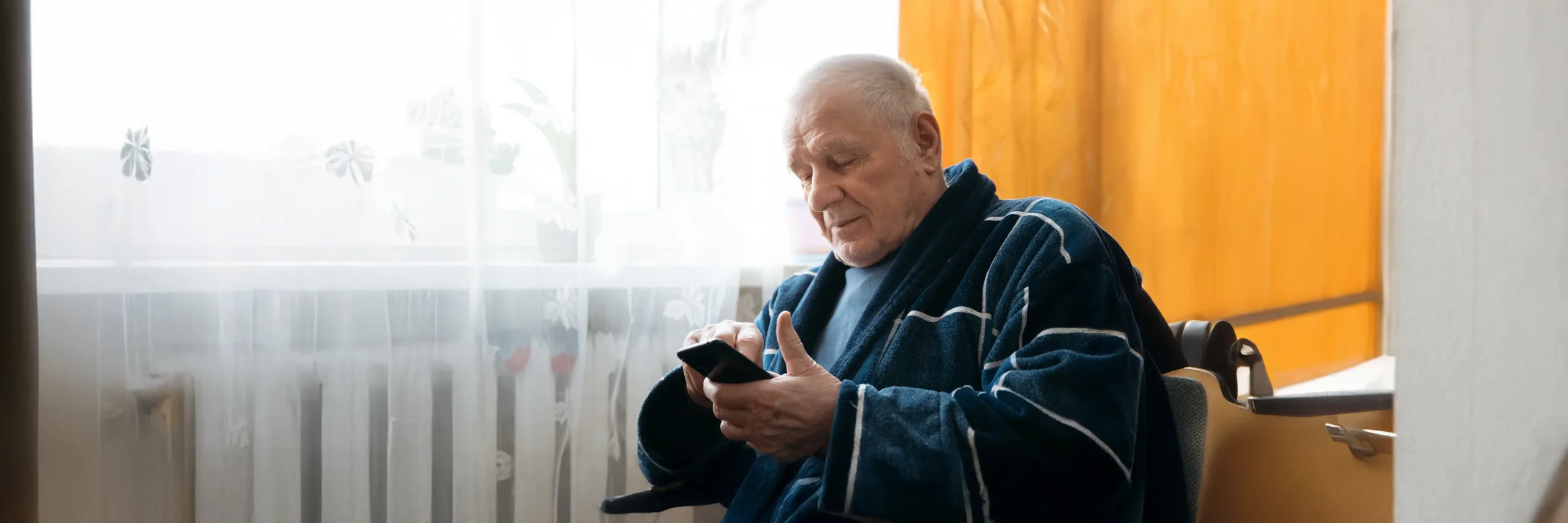Elderly man using smartphone at home