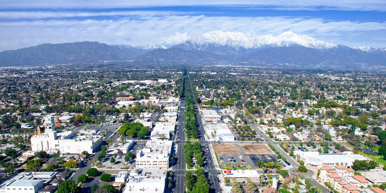 Aerial view of city with mountains in background.