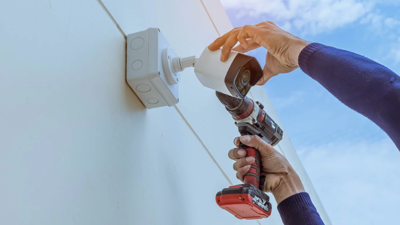 Installing a security camera on a wall.