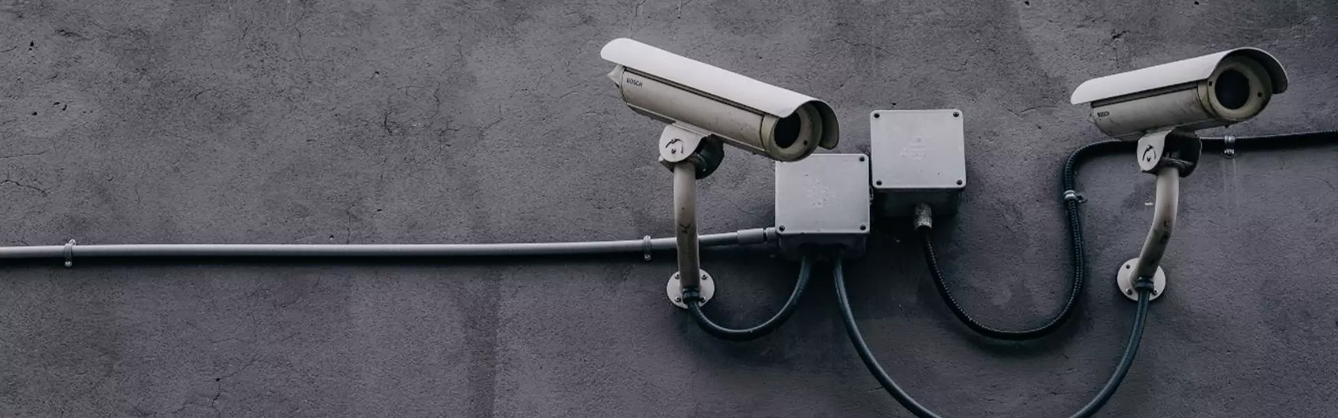 Security cameras mounted on a gray wall.