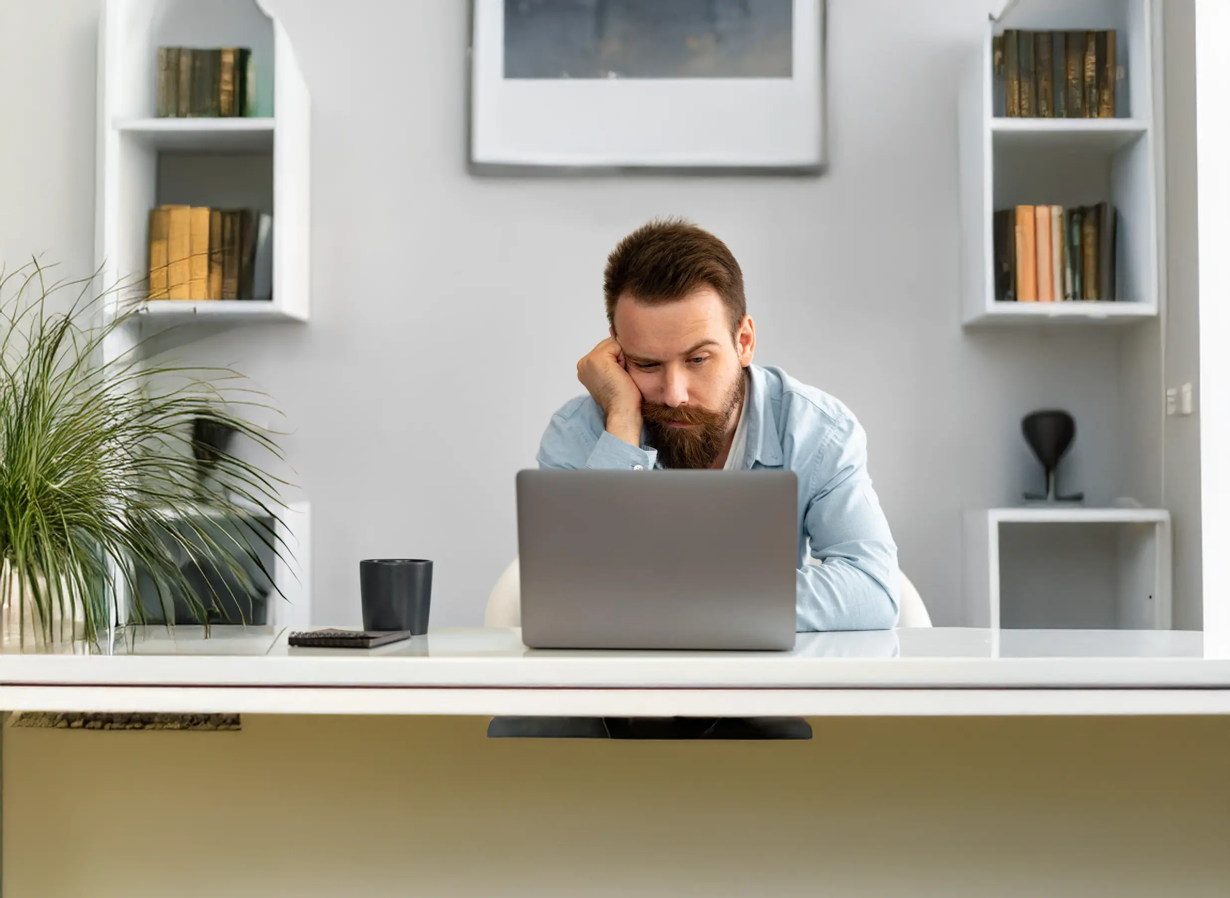 Man working on a laptop in a home office.