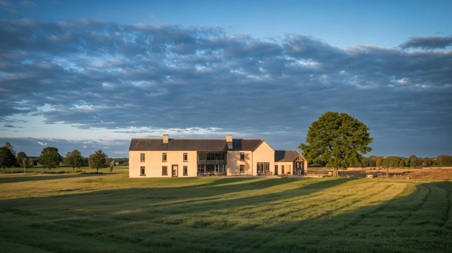 Modern house on grassy field under cloudy sky